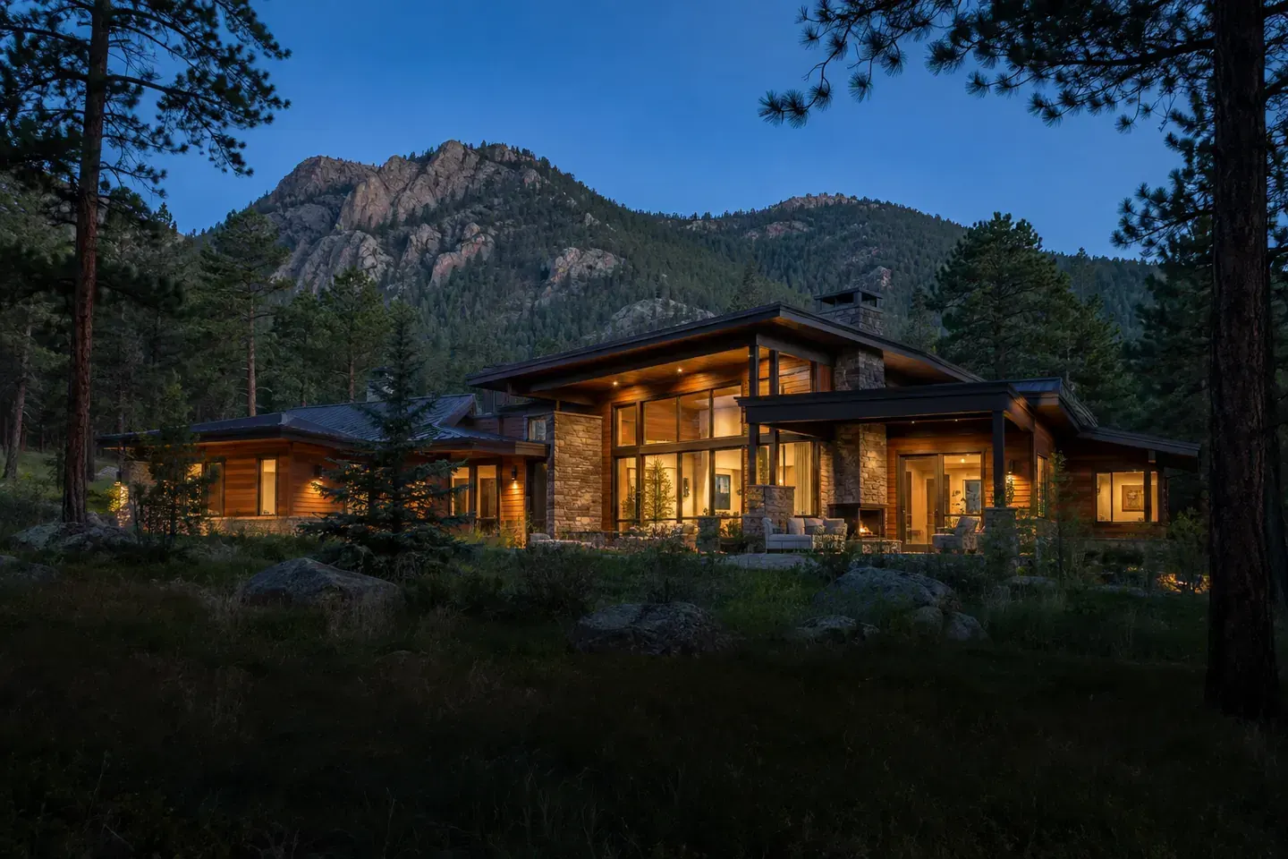 Timber and stone mountain home at dusk in the Colorado foothills